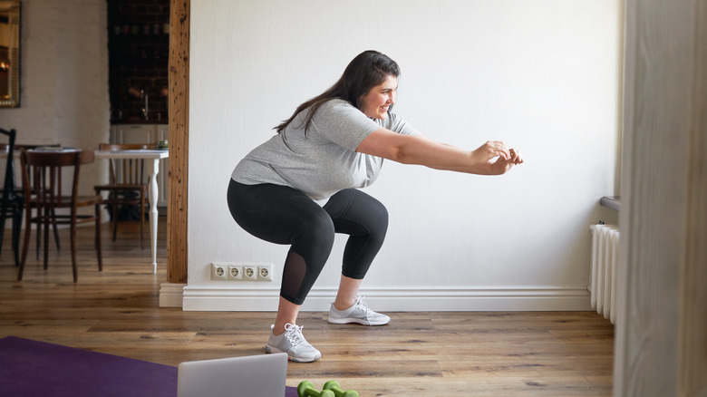 A woman does squats at home