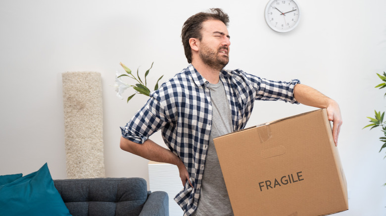 A man is in pain after lifting a heavy box