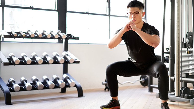 Man squatting at the gym