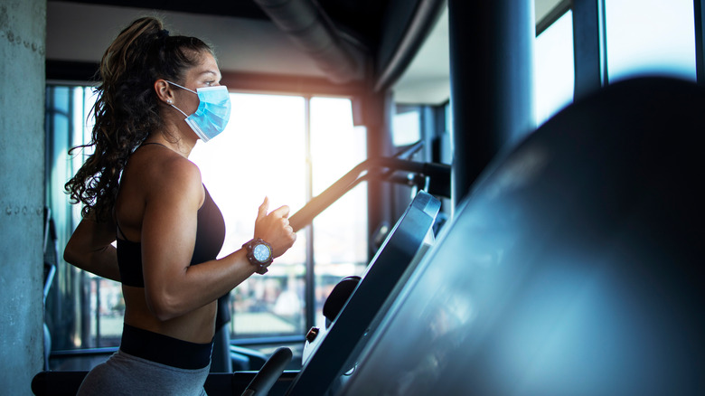 A woman wears a face mask at the gym