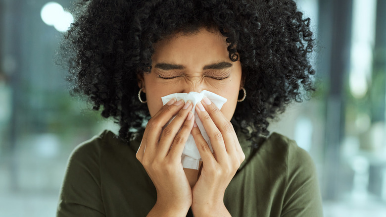 Woman blowing her nose