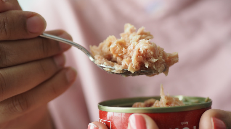 woman spooning out tuna fish