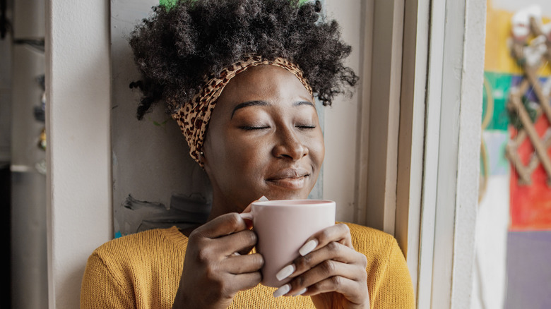 Smiling woman holding coffee mug