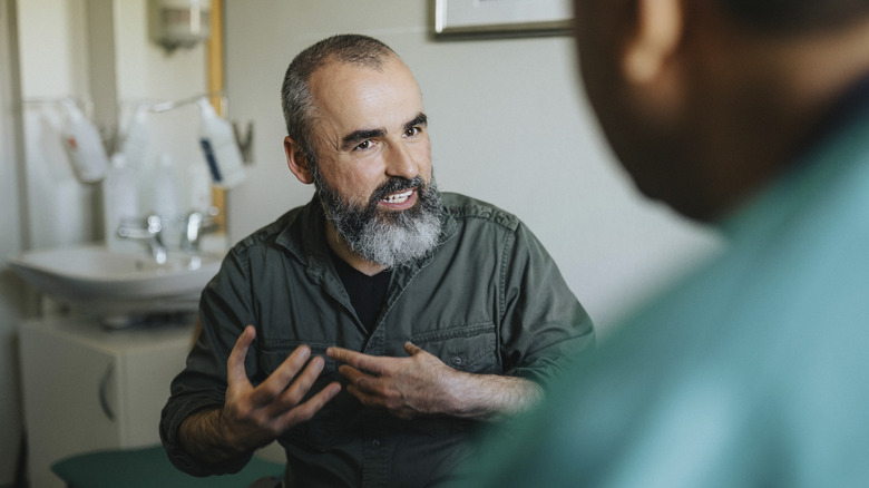 man describing something to his doctor