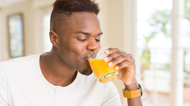 Man sipping orange juice