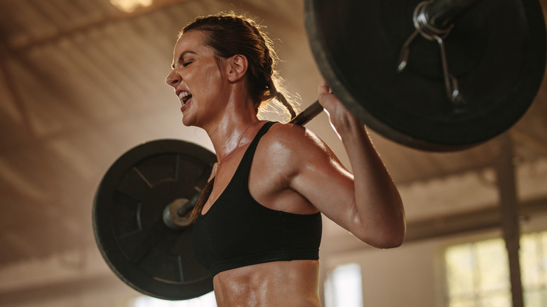 woman lifting heavy barbell