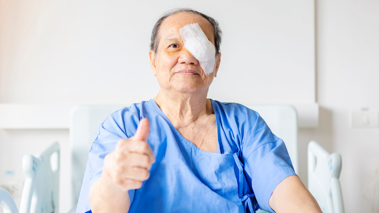 Elderly man with eye patch giving thumbs up
