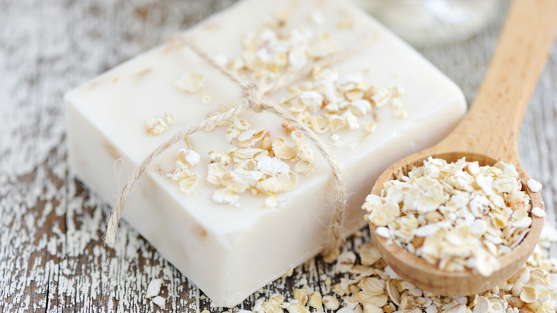 Spoonful of oats next to white soap bar