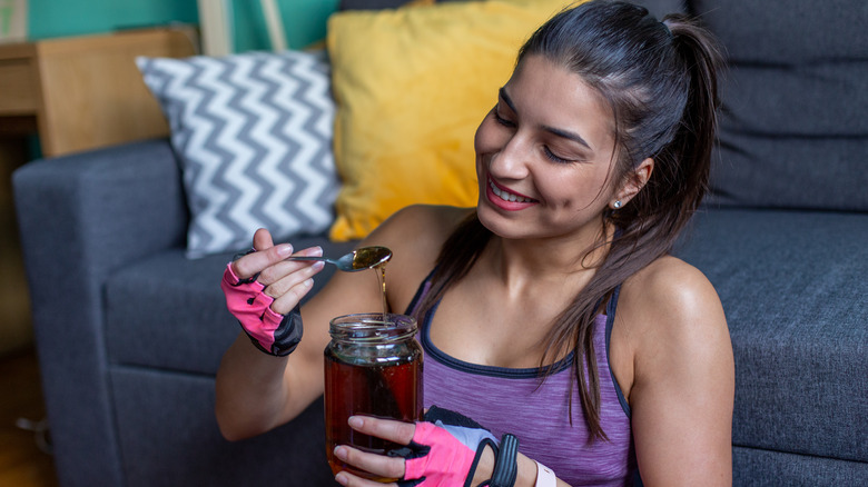 Woman eating honey before exercise