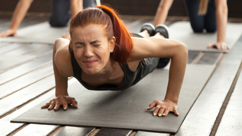 young woman struggling to do pushups