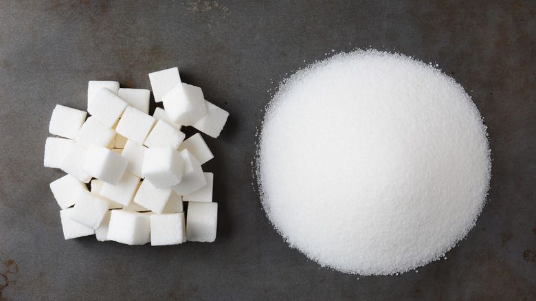 a pile of sugar beside a pile of sugar cubes