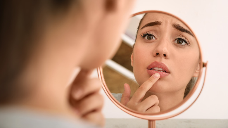 Woman looking at lip in mirror