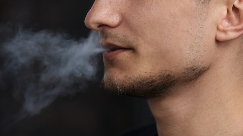 man blowing smoke puff
