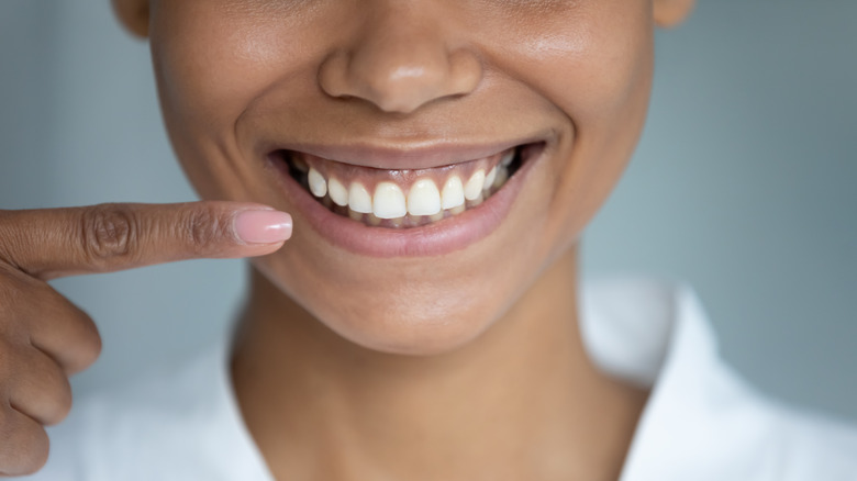 Woman with her finger near her teeth