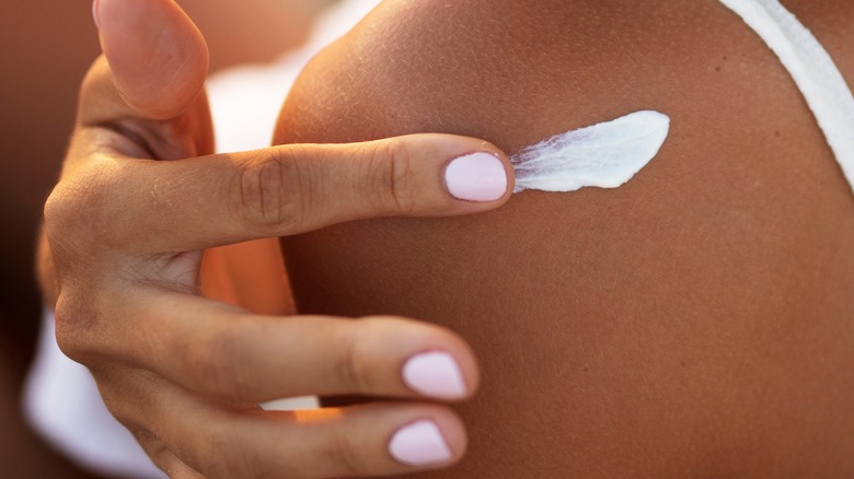 woman applying sunscreen on skin