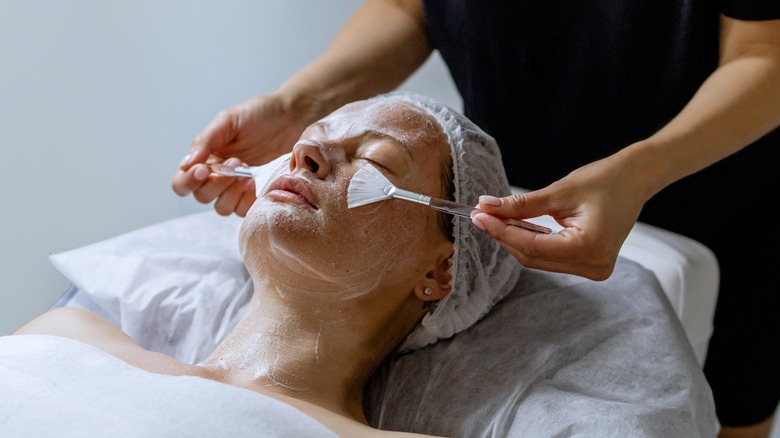 woman getting a facial from an aesthetician