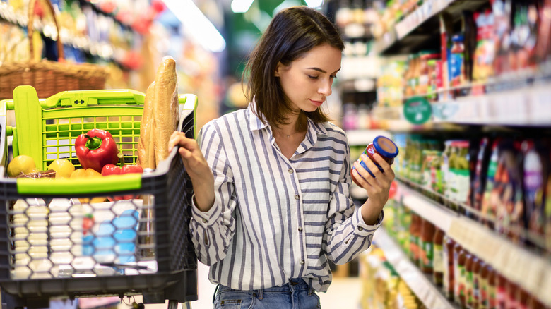 A woman reads a nutrition label