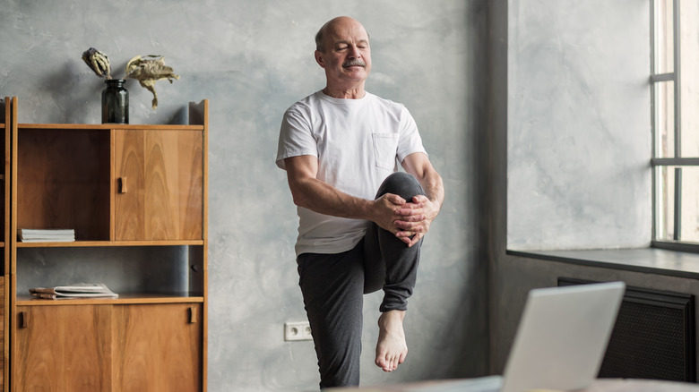 Man doing leg exercises at desk