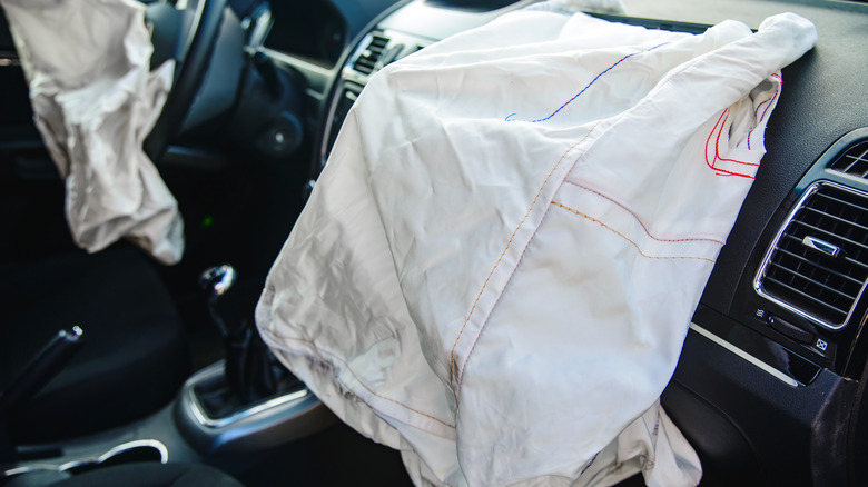 Picture of the inside of a car with both driver's and passenger's airbag deployed and deflated
