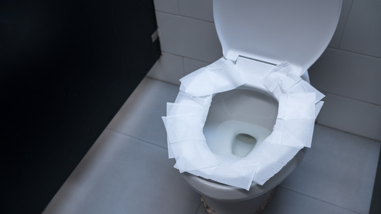 Toilet seat covered with toilet paper 