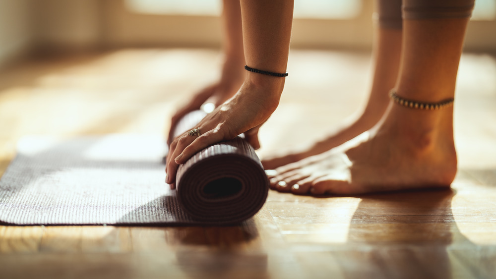 Woman rolling up yoga mat