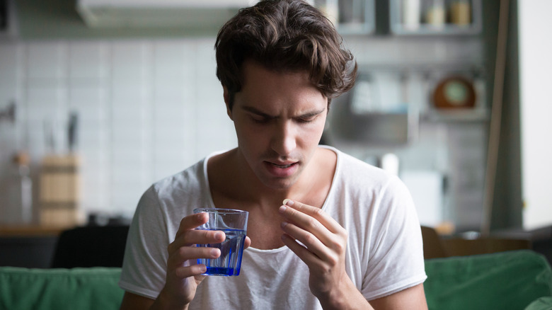 man swallowing a pill