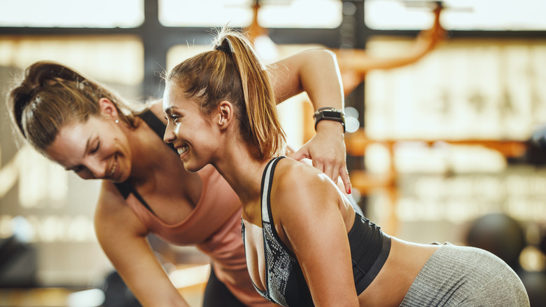 A personal trainer works with a client