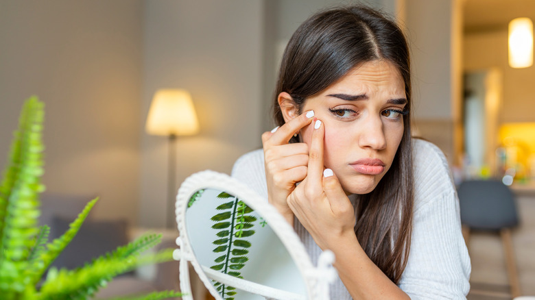 woman squeezing a pimple