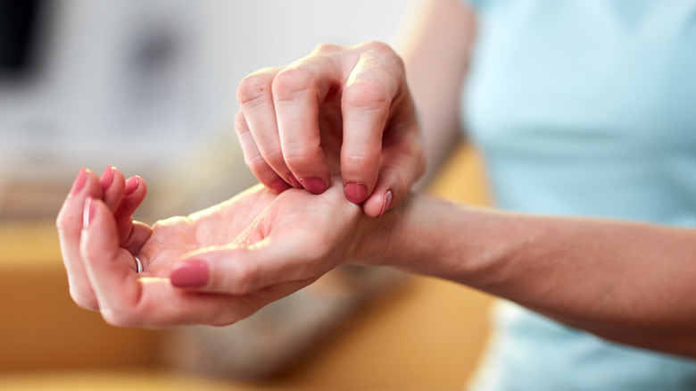 Person scratching itchy palm