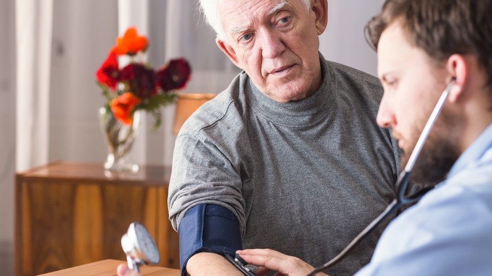 doctor taking man's blood pressure