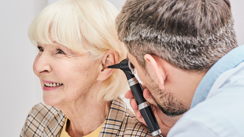 Older woman receiving an ear exam from doctor