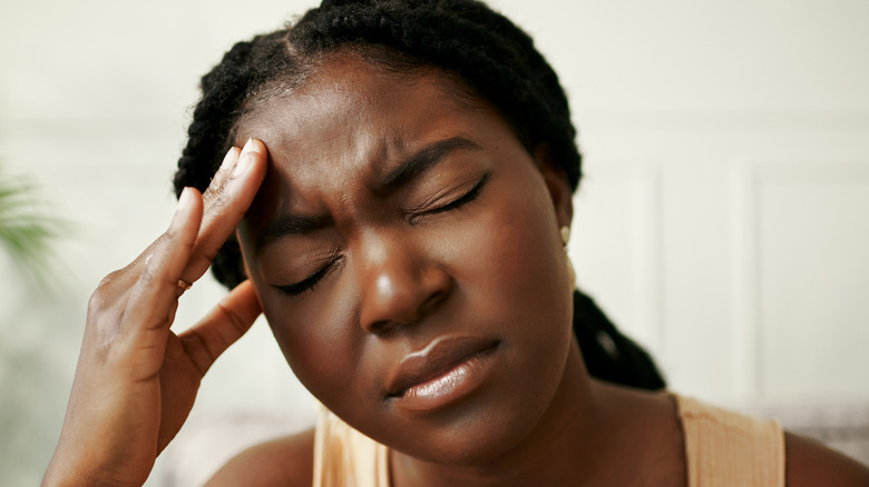 Wincing woman with headache