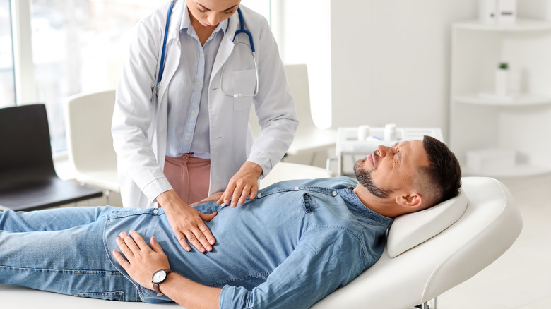 A doctor examines someone with indigestion