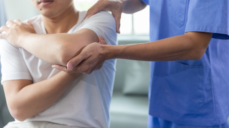 Doctor examining patient's shoulder