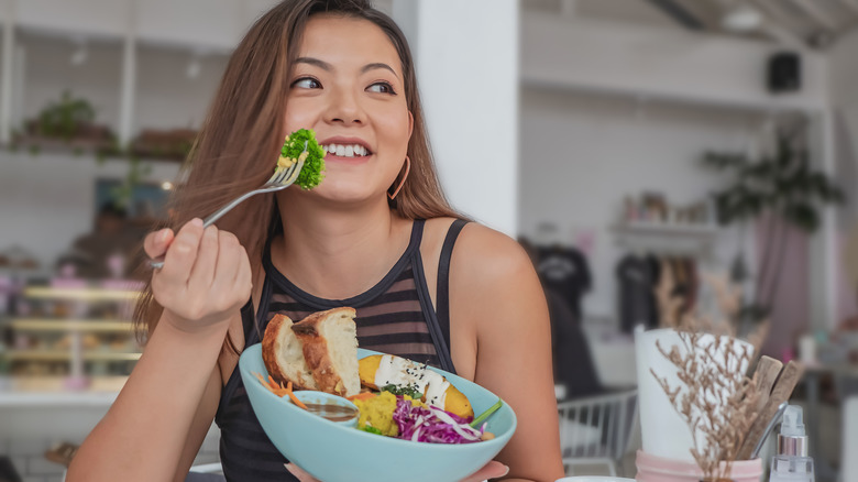 Woman eating broccoli