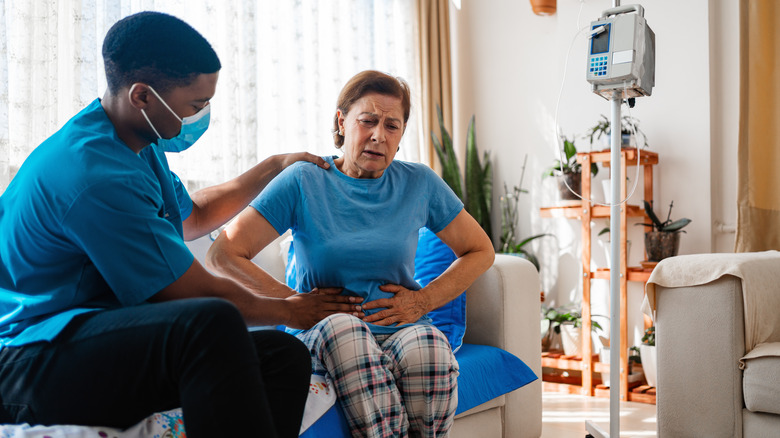 Medical professional examining patient with stomach pain