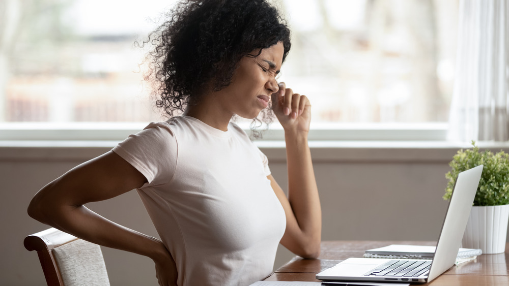 woman at desk with hurt back