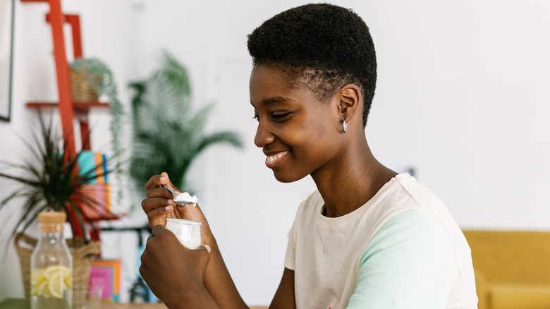 Young person eating spoonful of yogurt