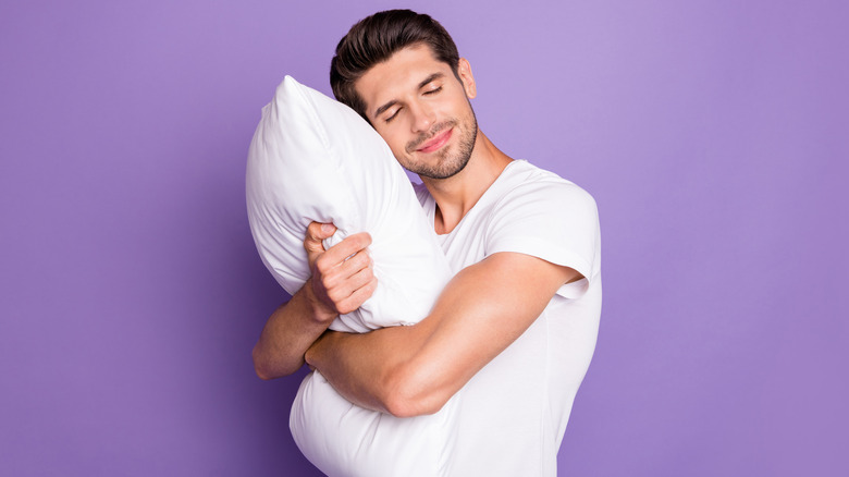 man hugging pillow