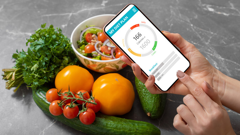 woman's using a food tracking app with vegetables in background