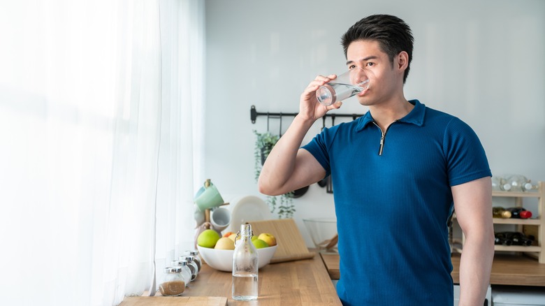 Young Asian man drinking water in the morning