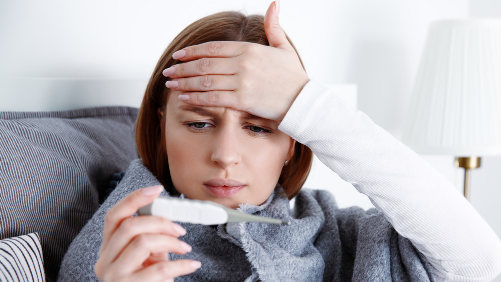 woman taking her own temperature