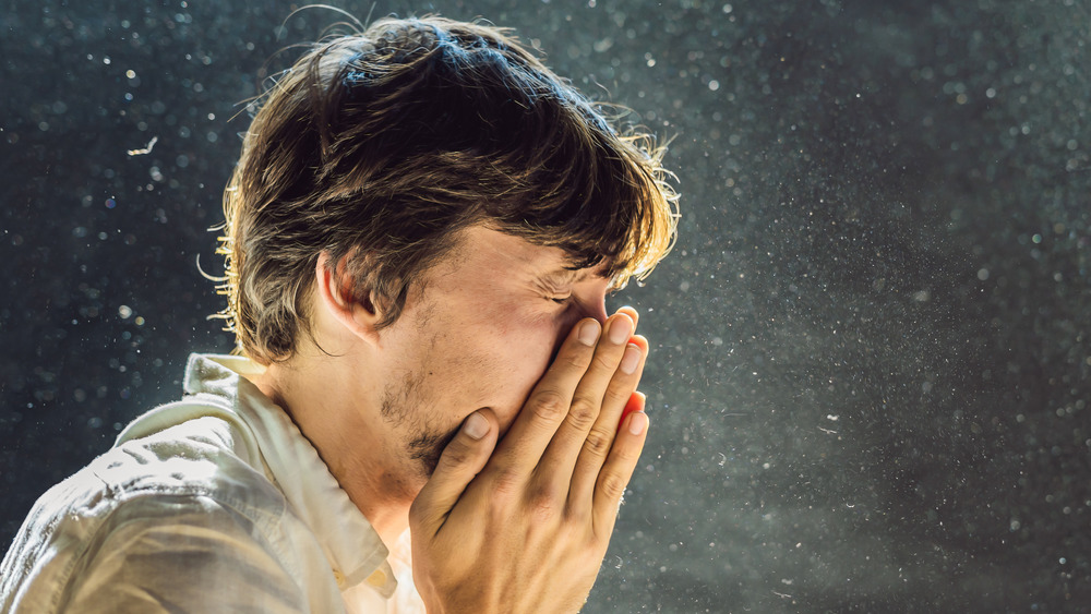 man sneezes from dust