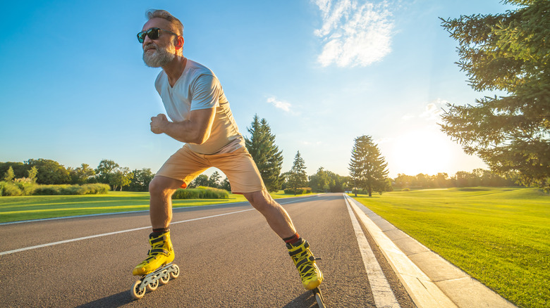 Older man rollerblading on road