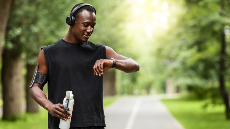 Man looking at his watch while working out