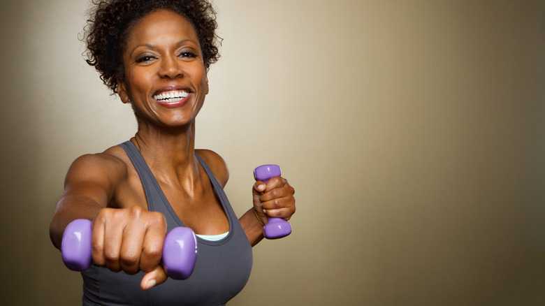 Woman smiling while doing a workout with weights