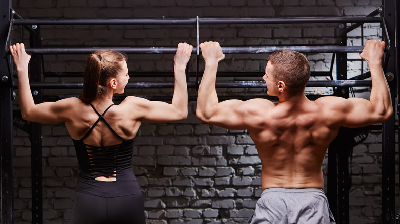 man and woman doing pull ups