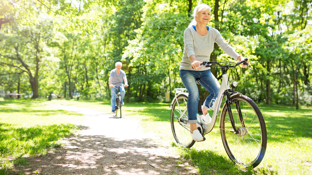 A man and a woman biking outdoors on a sunny day