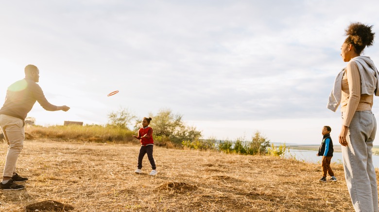 family of four playing frisbee