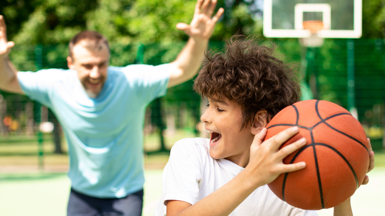 dad and son playing basketball